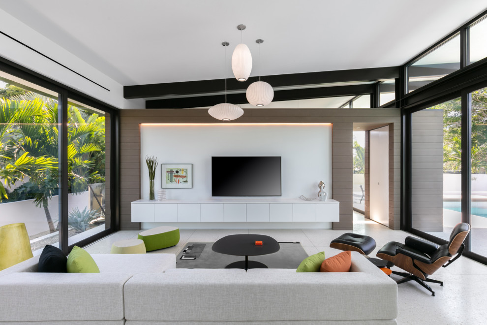 Immagine di un soggiorno minimalista di medie dimensioni e aperto con pareti bianche, pavimento in cemento, nessun camino, TV a parete e pavimento bianco