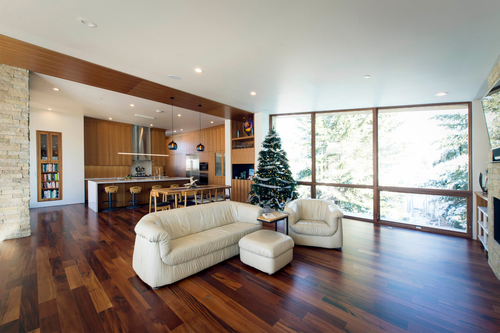 Example of a large trendy open concept medium tone wood floor living room design in Salt Lake City with white walls, a two-sided fireplace, a stone fireplace and a media wall