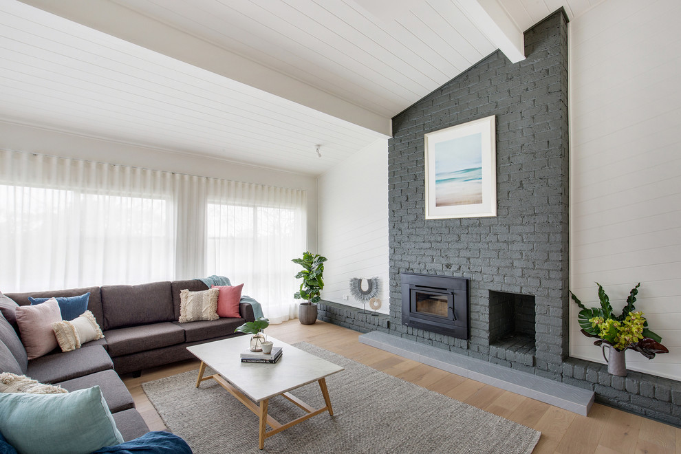 シドニーにある高級な広いコンテンポラリースタイルのおしゃれなLDK (白い壁、ライムストーンの床、標準型暖炉、レンガの暖炉まわり、ベージュの床) の写真