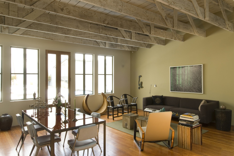 Industrial open plan living room feature wall in San Francisco with medium hardwood flooring.