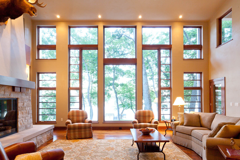 На фото: гостиная комната в классическом стиле с стандартным камином и фасадом камина из камня с