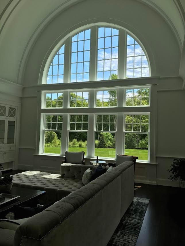 Идея дизайна: открытая гостиная комната среднего размера в стиле неоклассика (современная классика) с серыми стенами, темным паркетным полом, стандартным камином, фасадом камина из дерева и коричневым полом