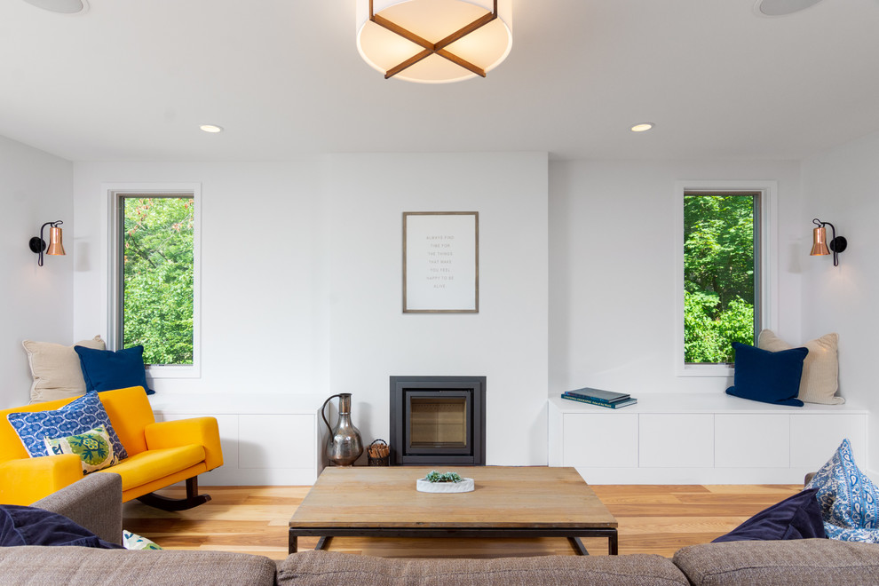 Imagen de salón de estilo de casa de campo sin televisor con paredes blancas, suelo de madera clara y estufa de leña
