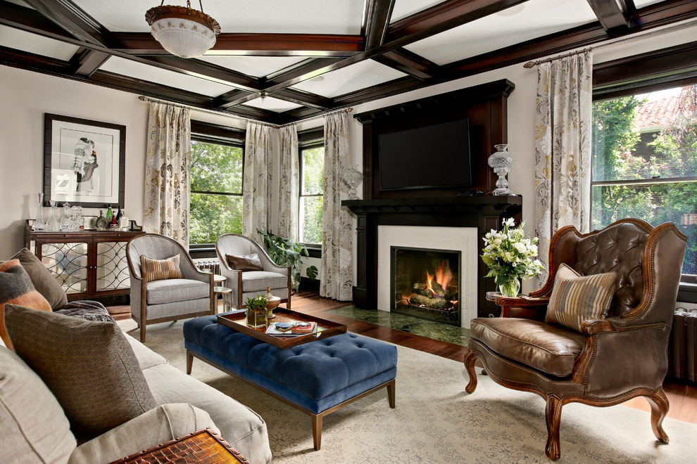 Klassisches Wohnzimmer mit Hausbar, beiger Wandfarbe, dunklem Holzboden, Kamin, gefliester Kaminumrandung und TV-Wand in Denver