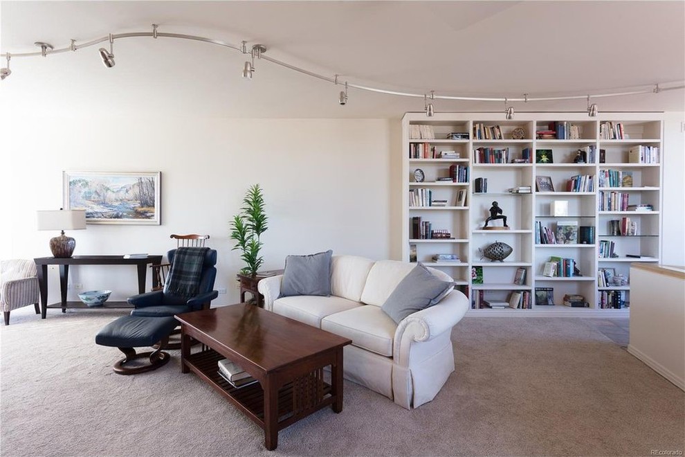 Inspiration pour un grand salon minimaliste ouvert avec une bibliothèque ou un coin lecture, un mur blanc, moquette, aucune cheminée, un téléviseur encastré et un sol beige.