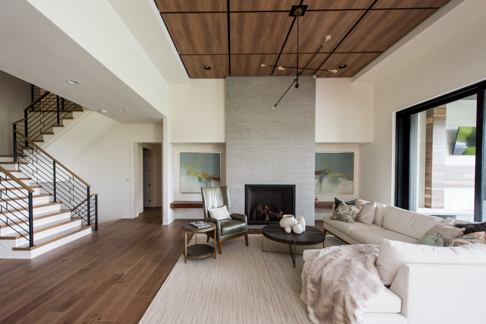 Réalisation d'un salon design de taille moyenne et ouvert avec une salle de réception, un mur beige, un sol en bois brun, une cheminée double-face et un téléviseur fixé au mur.