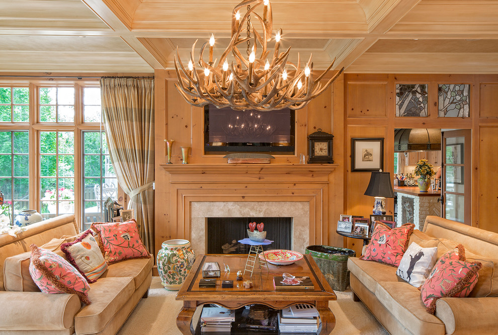 Стильный дизайн: гостиная комната в классическом стиле с стандартным камином, телевизором на стене и коричневым диваном - последний тренд