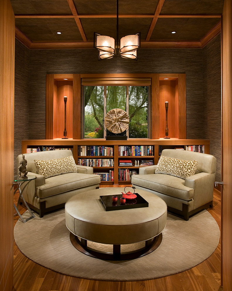 Zen enclosed medium tone wood floor living room library photo in Phoenix with brown walls