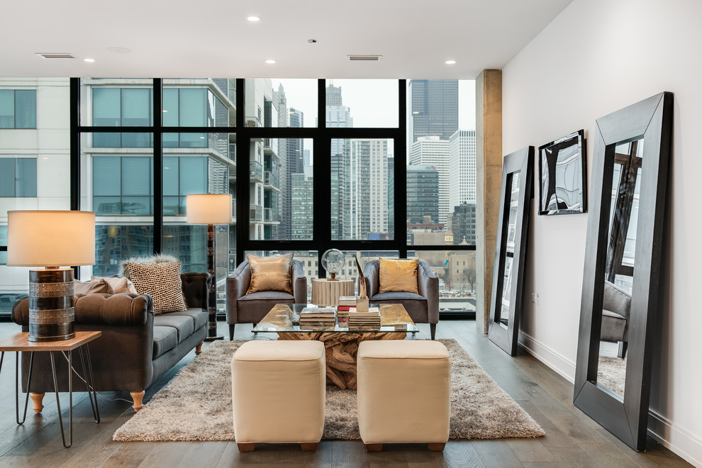 Immagine di un ampio soggiorno minimal aperto con pavimento in legno massello medio, pavimento marrone, pareti bianche e TV a parete