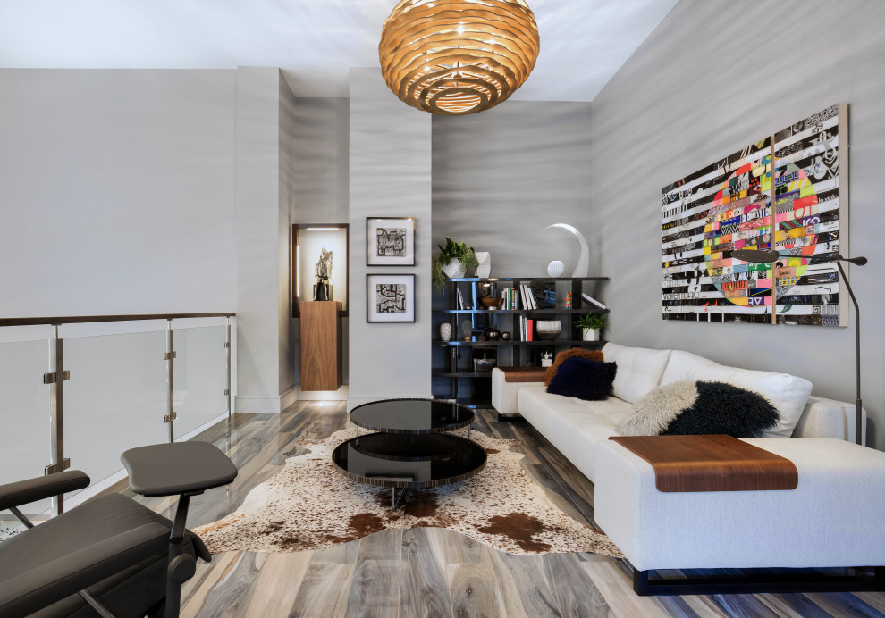Стильный дизайн: парадная, двухуровневая гостиная комната среднего размера в стиле модернизм с серыми стенами, светлым паркетным полом, стандартным камином, фасадом камина из плитки, телевизором на стене и серым полом - последний тренд