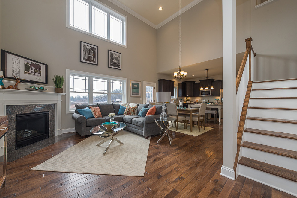 Cette image montre un grand salon design ouvert avec un mur gris, parquet foncé, une cheminée d'angle et un téléviseur indépendant.