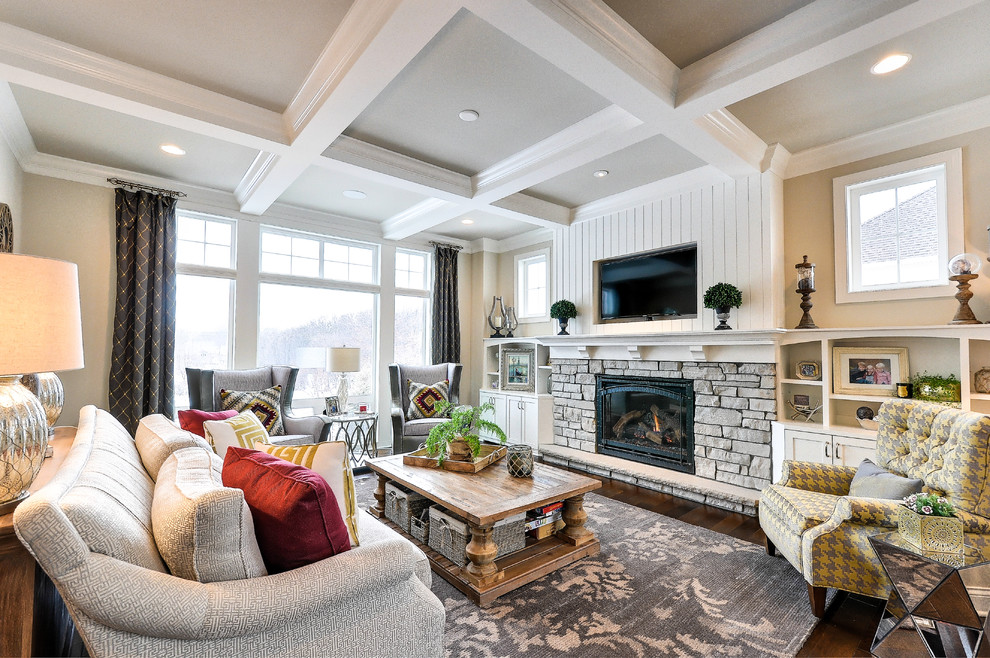 This is an example of a large traditional open plan living room feature wall in Minneapolis with beige walls, dark hardwood flooring, a standard fireplace, a stone fireplace surround and a wall mounted tv.