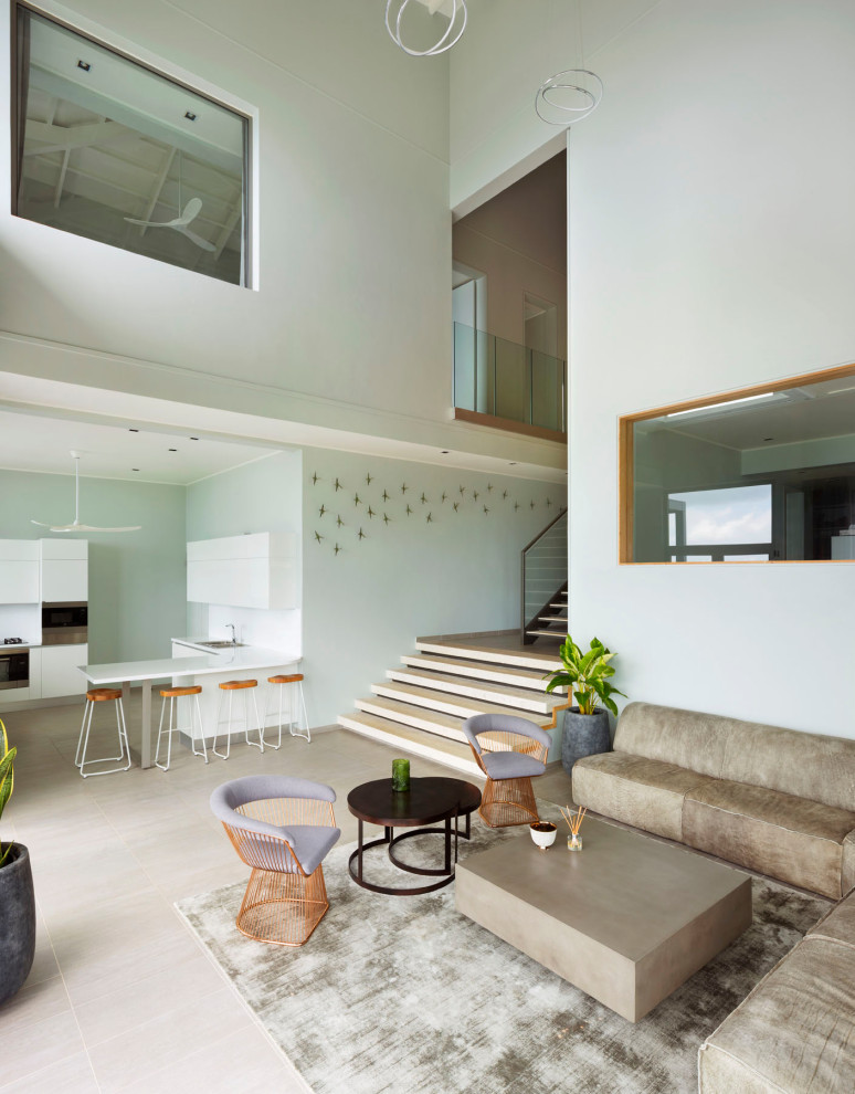 Modern inredning av ett stort allrum med öppen planlösning, med vita väggar, betonggolv och grått golv