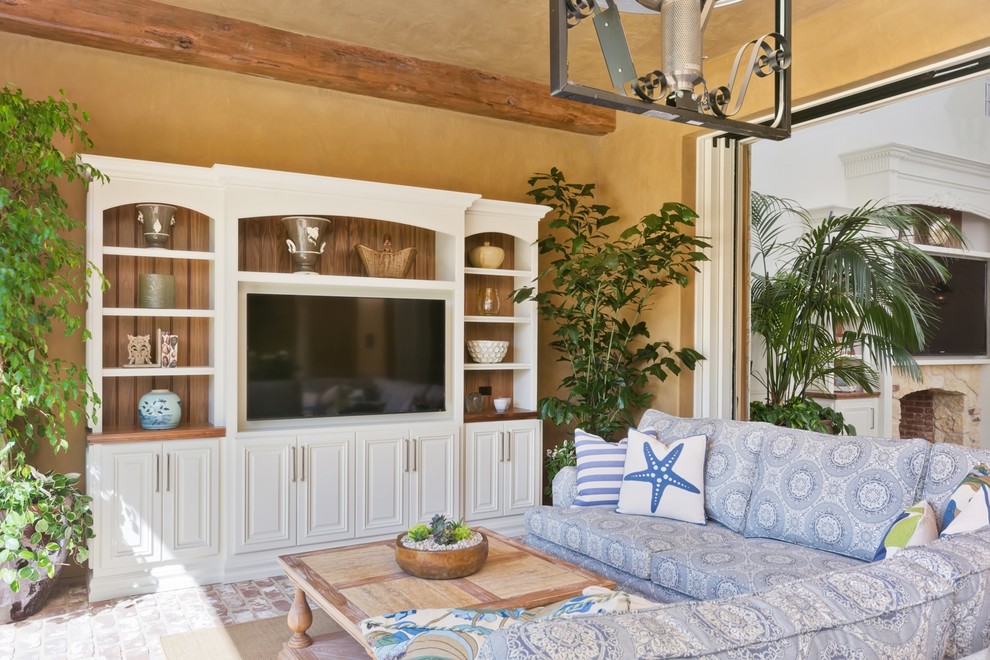 На фото: гостиная комната среднего размера в морском стиле с коричневыми стенами, кирпичным полом и телевизором на стене с