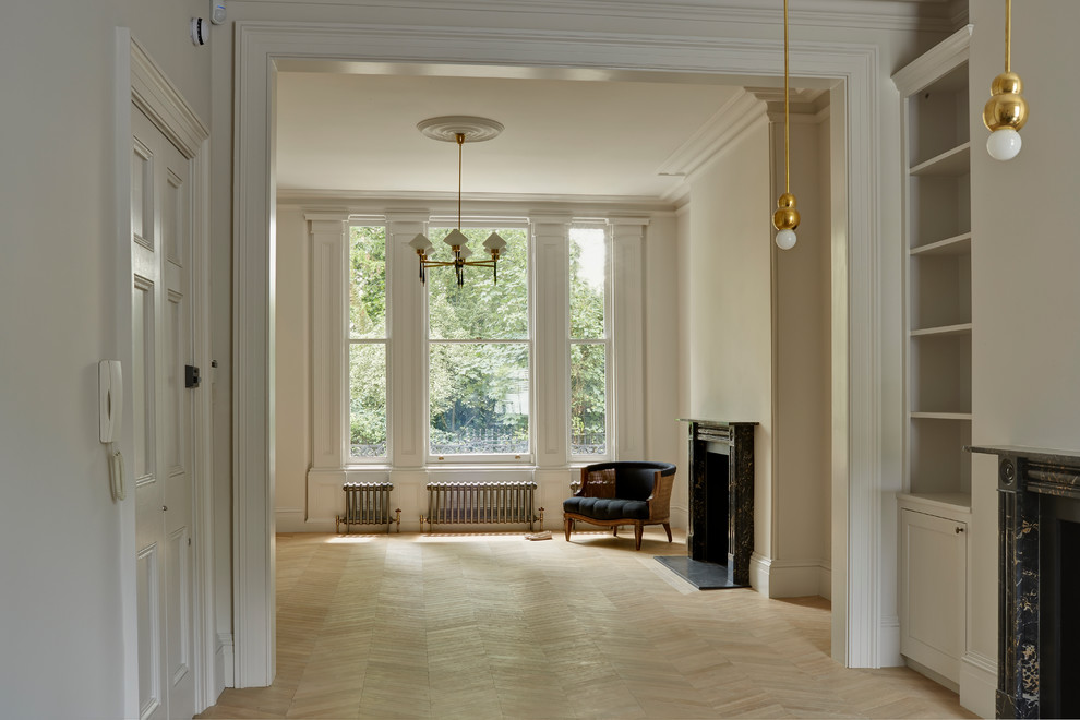 Cette photo montre un salon chic ouvert et de taille moyenne avec un mur blanc, parquet clair, une cheminée standard, un manteau de cheminée en pierre et un sol marron.