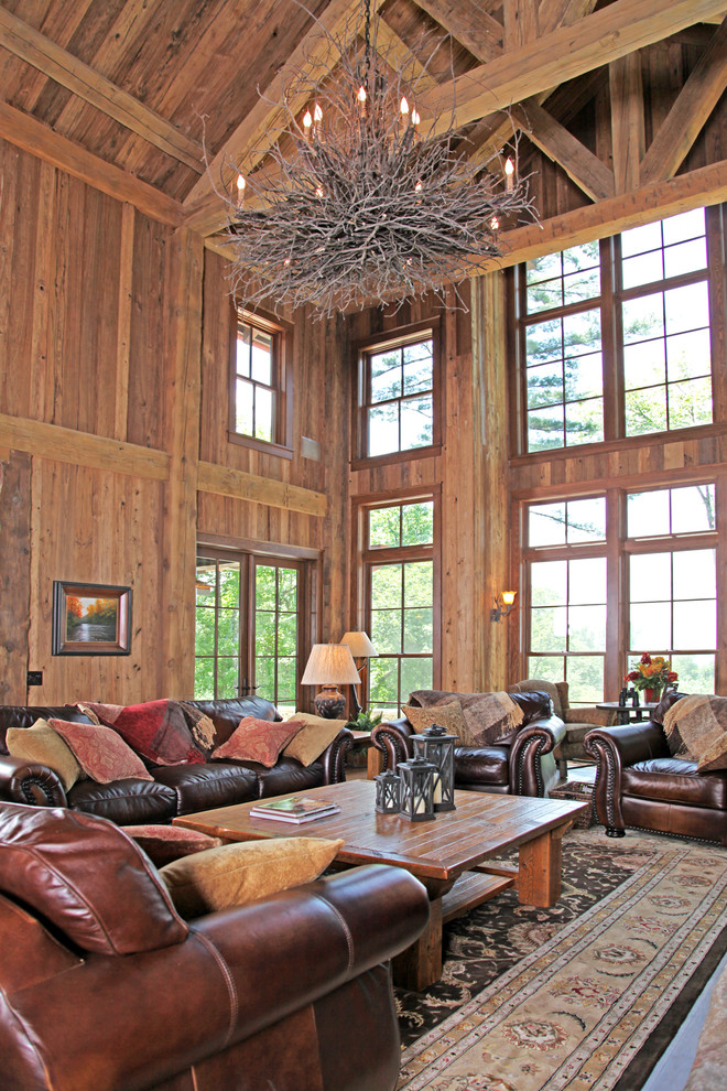 Пример оригинального дизайна: большая гостиная комната в стиле рустика с коричневыми стенами, темным паркетным полом, стандартным камином и фасадом камина из камня