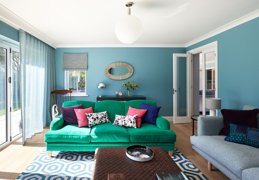 Diseño de salón cerrado contemporáneo de tamaño medio con paredes azules, suelo de madera clara, estufa de leña, televisor independiente y suelo marrón
