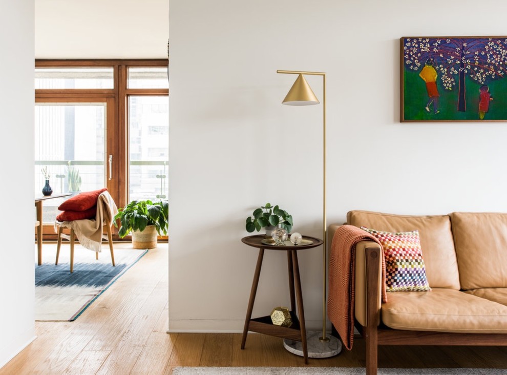 Abgetrenntes, Mittelgroßes Skandinavisches Wohnzimmer mit braunem Boden, weißer Wandfarbe und hellem Holzboden in London