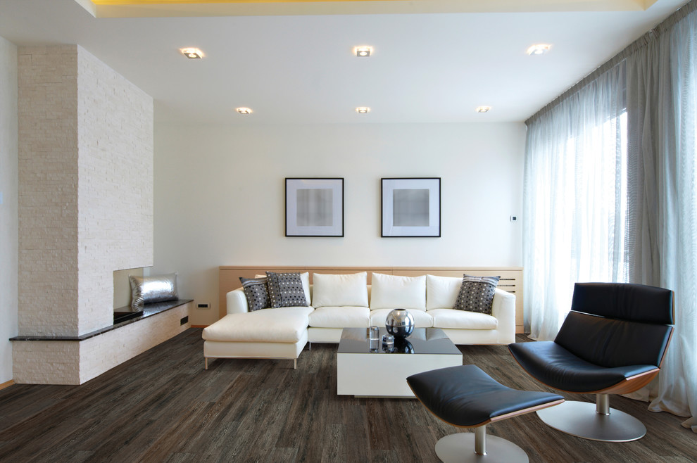 Esempio di un soggiorno minimalista con pareti bianche, pavimento in vinile, camino classico e cornice del camino in pietra