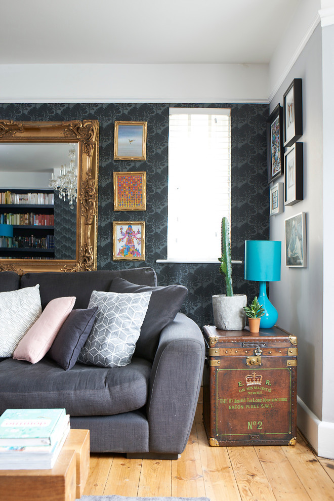 На фото: гостиная комната в стиле фьюжн с черными стенами и паркетным полом среднего тона с