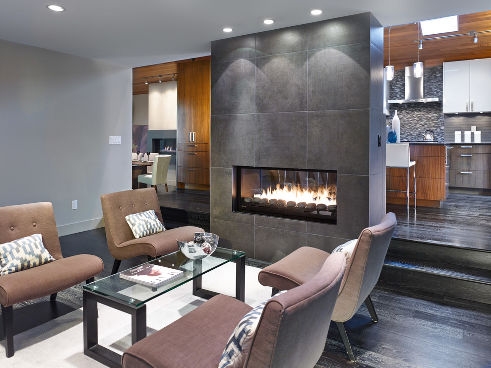 Cette photo montre un salon tendance de taille moyenne et ouvert avec un mur gris, parquet foncé, une cheminée double-face et un manteau de cheminée en carrelage.