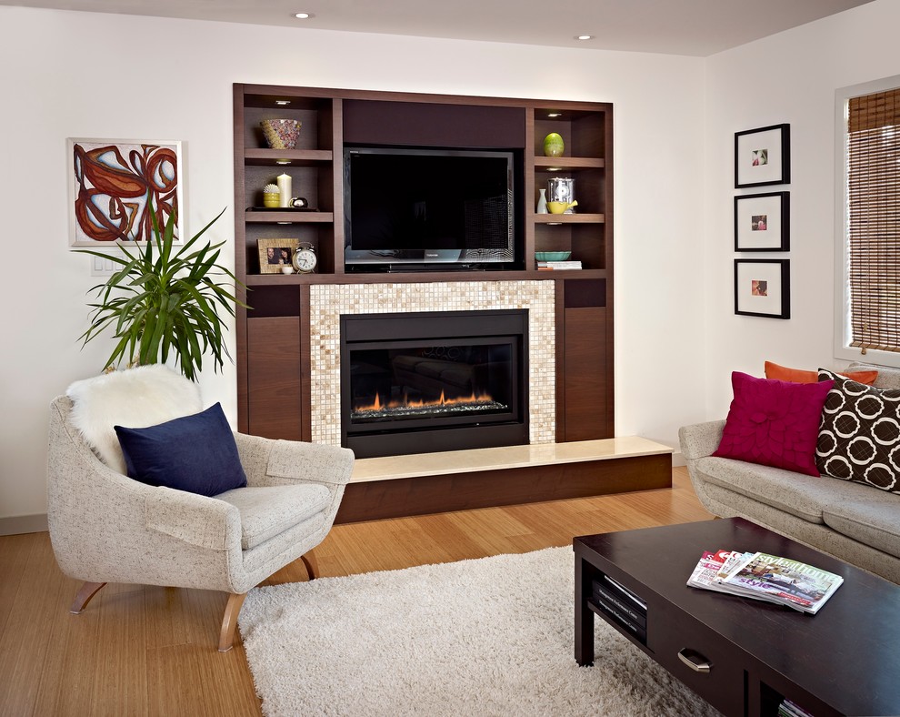 Mittelgroßes, Offenes Modernes Wohnzimmer mit weißer Wandfarbe, braunem Holzboden, Gaskamin, gefliester Kaminumrandung und Multimediawand in Edmonton