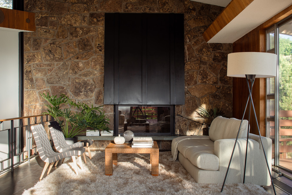 Cette photo montre un salon tendance avec un mur marron, une cheminée standard et un sol gris.
