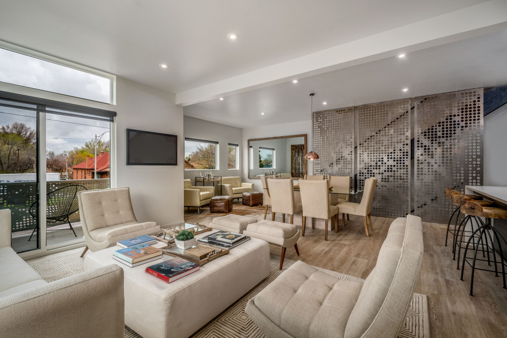 Esempio di un grande soggiorno design aperto con pareti bianche, TV a parete e pavimento beige