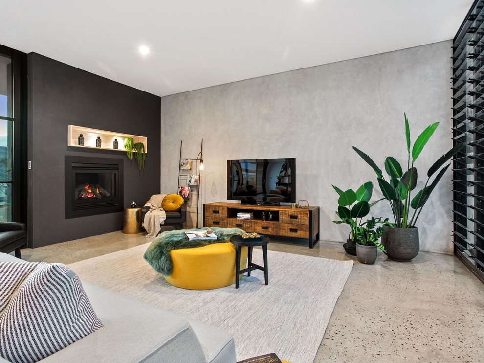 Idéer för funkis vardagsrum, med grå väggar, betonggolv, en standard öppen spis, en fristående TV och grått golv