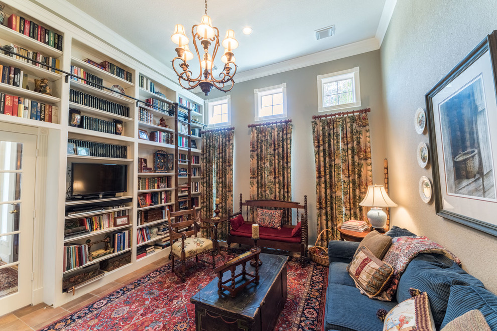 Kleine, Offene Klassische Bibliothek ohne Kamin mit beiger Wandfarbe, Terrakottaboden und freistehendem TV in Houston