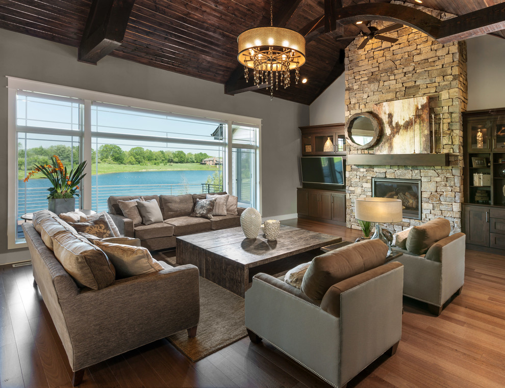 Inspiration for a mid-sized timeless open concept medium tone wood floor living room remodel in Milwaukee with a standard fireplace, a stone fireplace and a wall-mounted tv