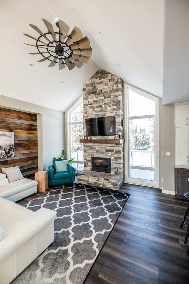 Inspiration for a medium sized rustic open plan living room in Calgary with grey walls, vinyl flooring, a wood burning stove, a stone fireplace surround and a wall mounted tv.