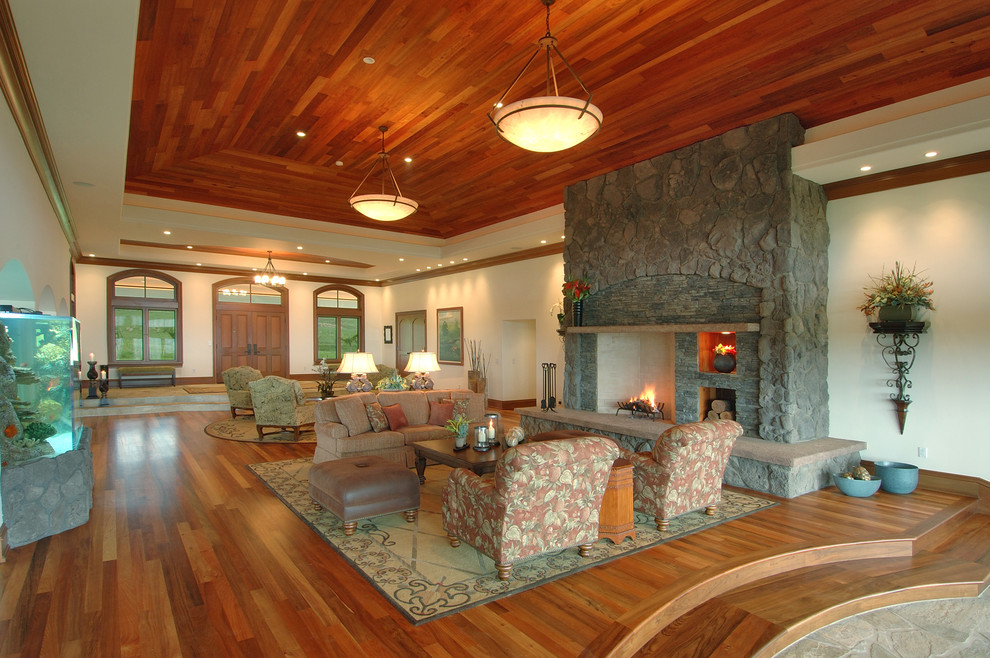 Пример оригинального дизайна: большая парадная, открытая гостиная комната в современном стиле с фасадом камина из камня, белыми стенами, паркетным полом среднего тона, стандартным камином и коричневым полом без телевизора