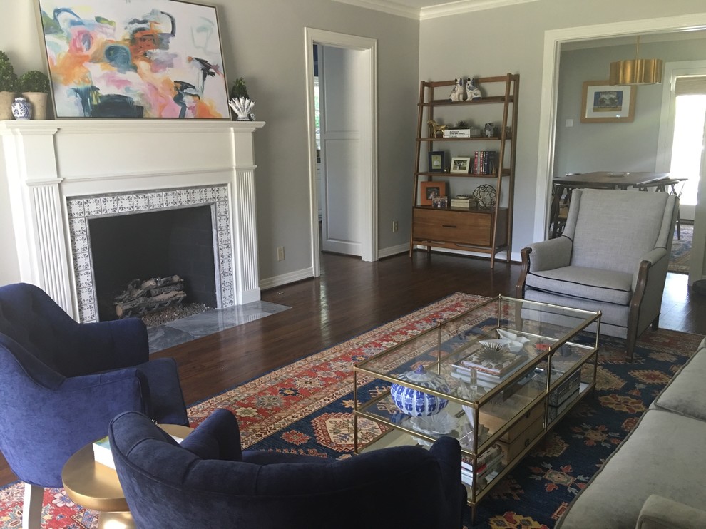 Mittelgroßes, Offenes Mid-Century Wohnzimmer mit grauer Wandfarbe, braunem Holzboden, Kamin, Kaminumrandung aus Holz, freistehendem TV und braunem Boden in Dallas
