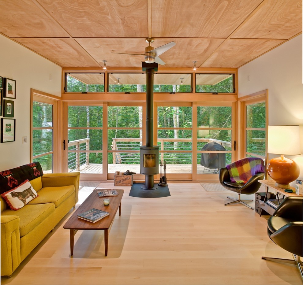 Modernes Wohnzimmer mit hellem Holzboden und Kaminofen in Seattle