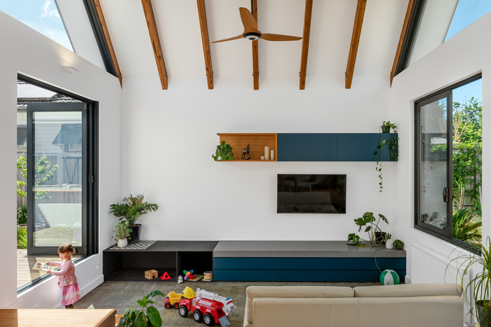 Modernes Wohnzimmer mit weißer Wandfarbe, Betonboden, TV-Wand, grauem Boden, freigelegten Dachbalken und gewölbter Decke in Melbourne