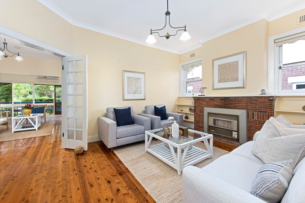 Small transitional enclosed living room photo in Sydney with a standard fireplace and a brick fireplace