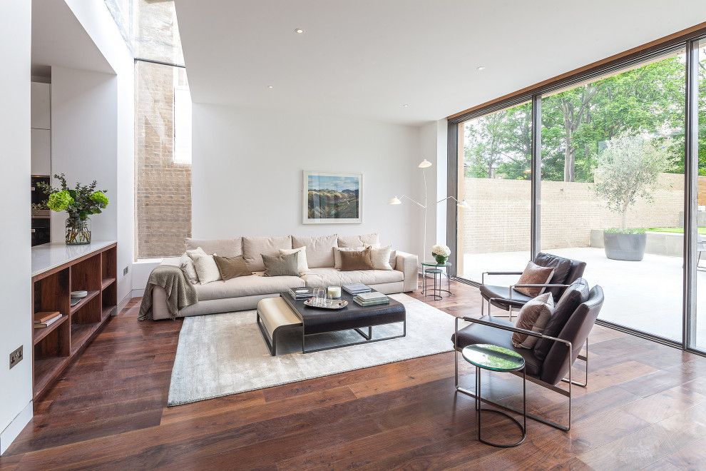 This is an example of an expansive contemporary living room in Hertfordshire with white walls, dark hardwood flooring and brown floors.