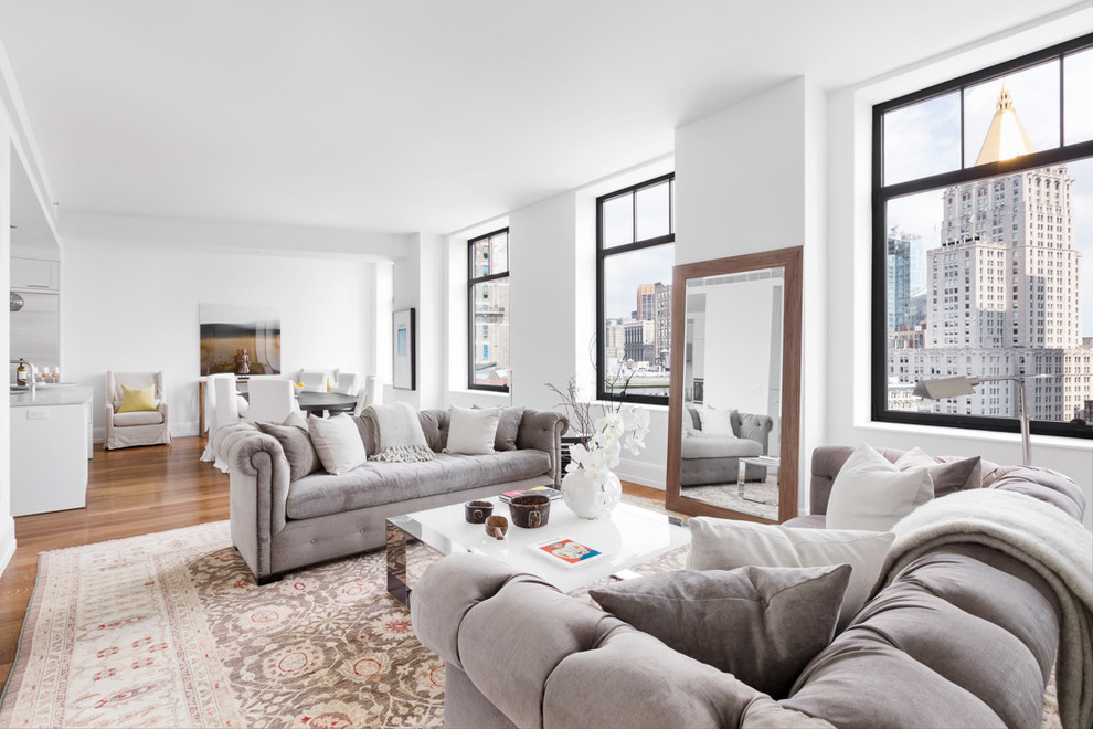 Transitional open concept medium tone wood floor living room photo in New York with white walls