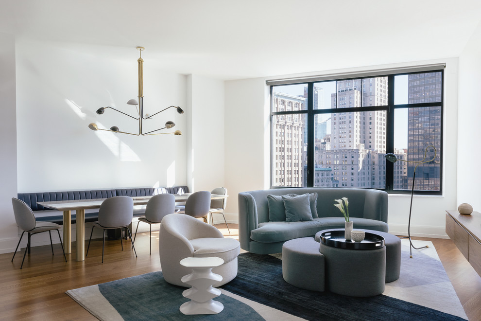 Example of a mid-sized trendy open concept medium tone wood floor and brown floor living room design in New York with white walls and a wall-mounted tv