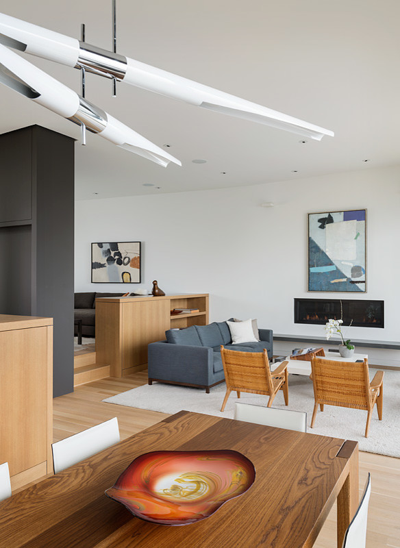 Diseño de salón abierto minimalista de tamaño medio con paredes blancas, suelo de madera clara, chimenea lineal y marco de chimenea de yeso
