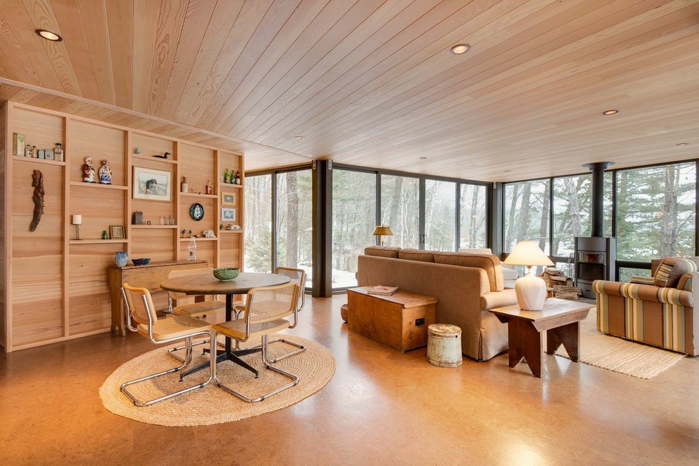 Esempio di un grande soggiorno moderno aperto con stufa a legna, cornice del camino in metallo e pavimento in sughero