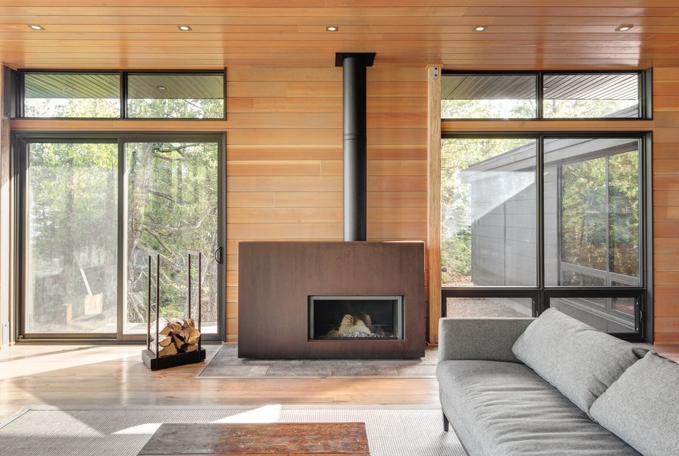 Idées déco pour un grand salon moderne ouvert avec parquet clair, un poêle à bois et un manteau de cheminée en métal.