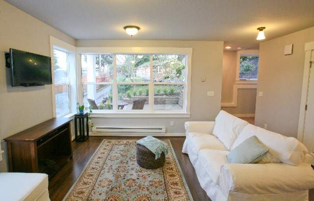 Example of a small open concept laminate floor living room design in Seattle with white walls