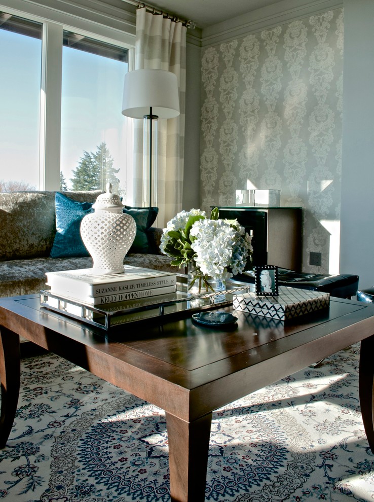 Idée de décoration pour un grand salon tradition ouvert avec un mur gris, un sol en bois brun, une cheminée standard et un téléviseur fixé au mur.