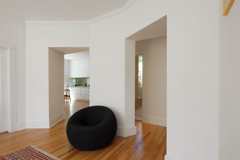 Exempel på ett mellanstort klassiskt vardagsrum, med vita väggar, mellanmörkt trägolv och brunt golv