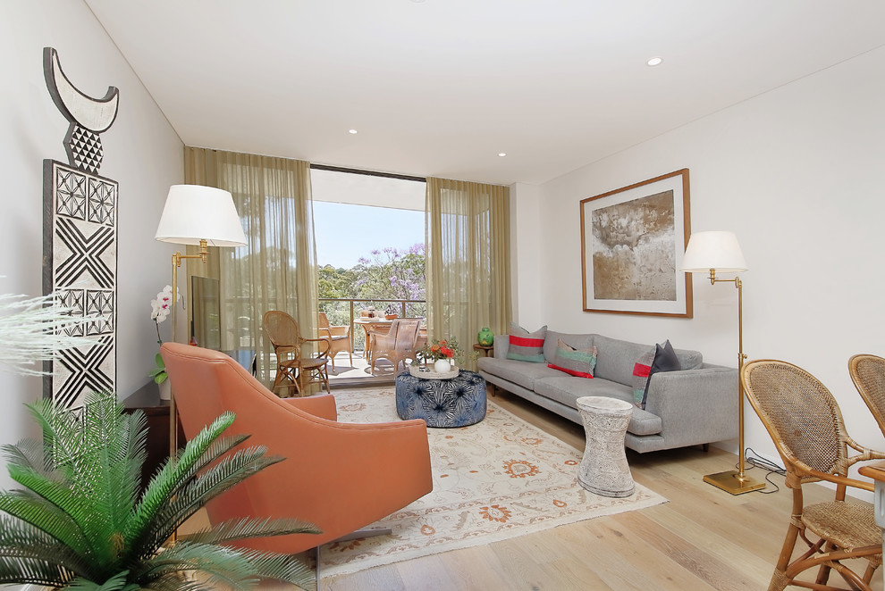 Ispirazione per un soggiorno design aperto con pareti bianche, parquet chiaro e pavimento beige