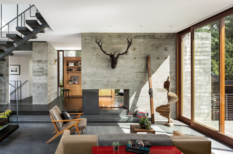 Источник вдохновения для домашнего уюта: открытая гостиная комната в современном стиле с двусторонним камином, фасадом камина из бетона, серым полом и ковром на полу