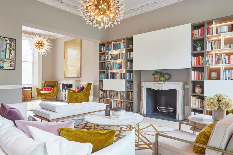 Transitional open concept light wood floor and beige floor living room library photo in London with beige walls, a standard fireplace and a wall-mounted tv