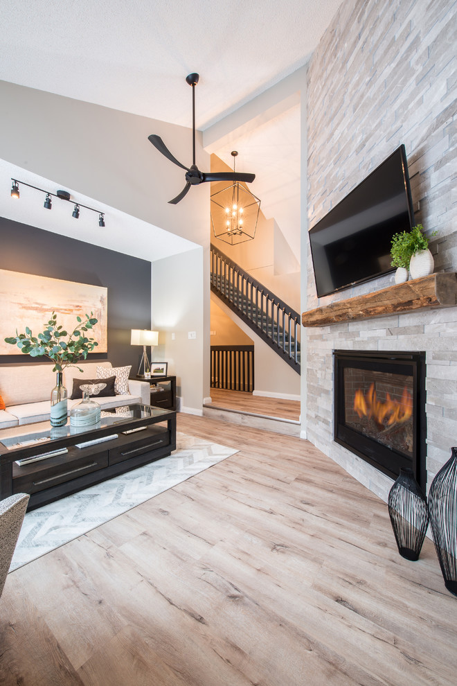 Photo of a medium sized classic open plan living room in Edmonton with grey walls, vinyl flooring, a corner fireplace, a stone fireplace surround, a wall mounted tv and multi-coloured floors.